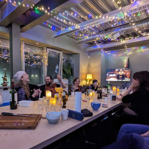 kerstlampjes boven de tafel, lachende mensen